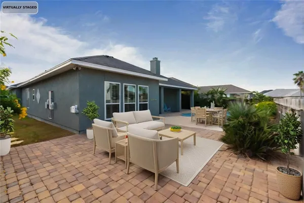 a view of a house with backyard and sitting area