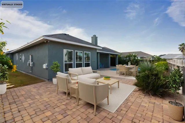 a view of a house with backyard and sitting area