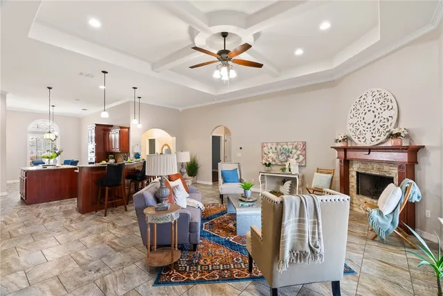 a living room with furniture a fireplace and a chandelier