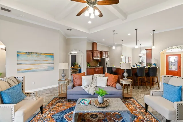 a living room with furniture kitchen view and a chandelier
