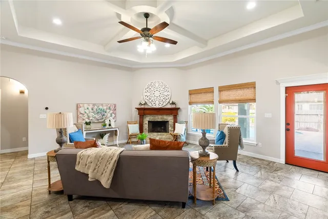 a living room with furniture a fireplace and a large window