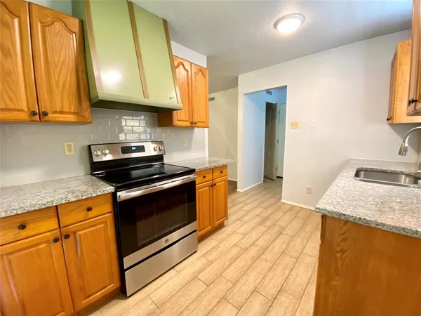 a kitchen with stainless steel appliances granite countertop a sink a stove and a microwave