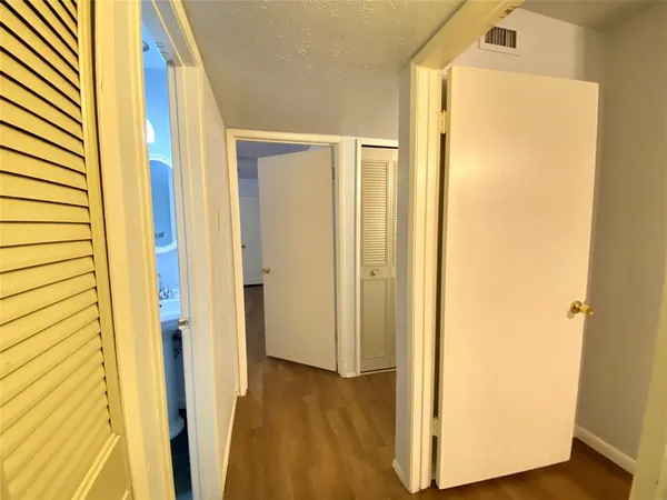 a view of a hallway with wooden floor