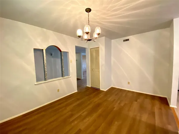 a view of a bedroom with a chandelier fan and wooden floor