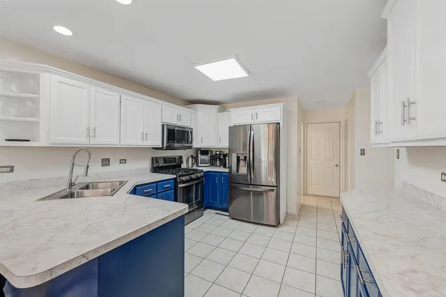a kitchen with stainless steel appliances granite countertop a refrigerator sink and stove