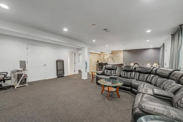 a living room with furniture and a gym machine