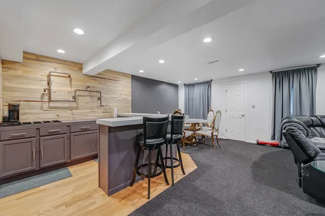 a kitchen with kitchen island granite countertop furniture a sink a stove and a dining table with wooden floor