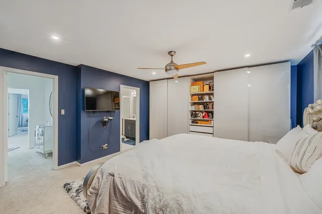 a bedroom with a bed and a flat tv screen on dresser