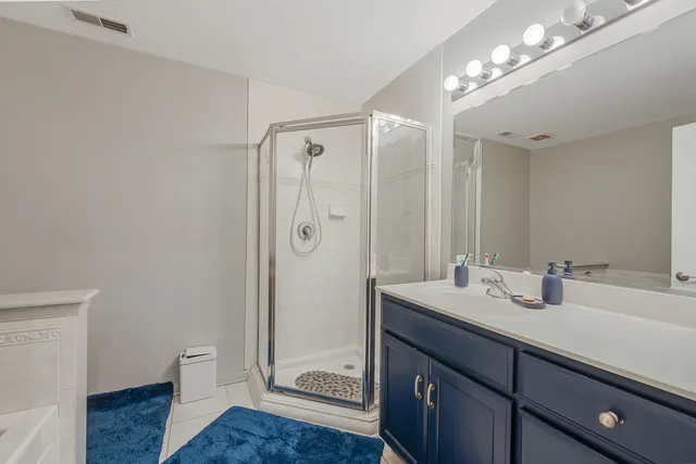 a bathroom with a double vanity sink mirror and shower