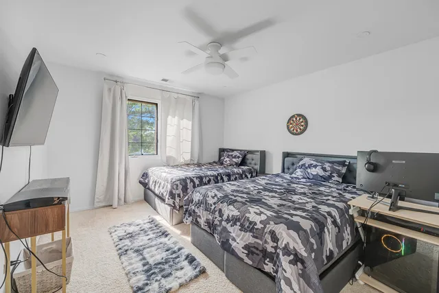 a bedroom with two beds and a flat screen tv