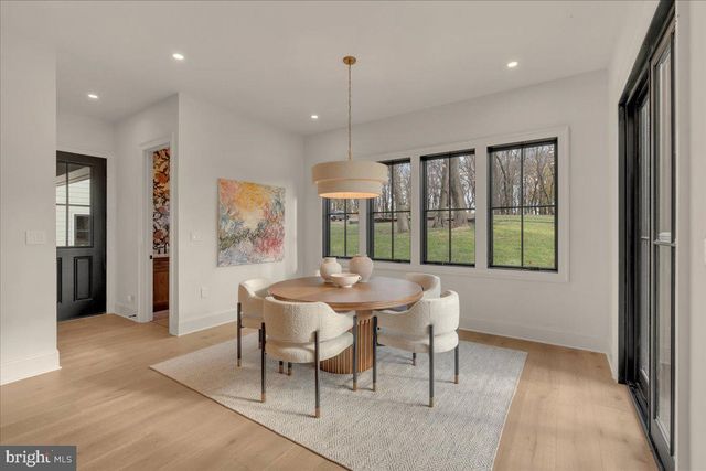 a view of a dining room with furniture large windows and wooden floor