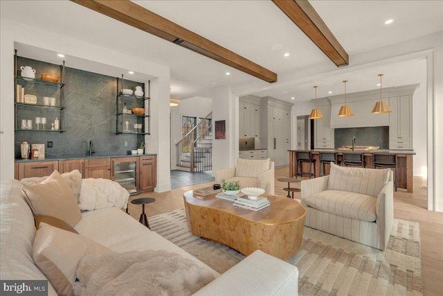 a living room with furniture kitchen view and a large window