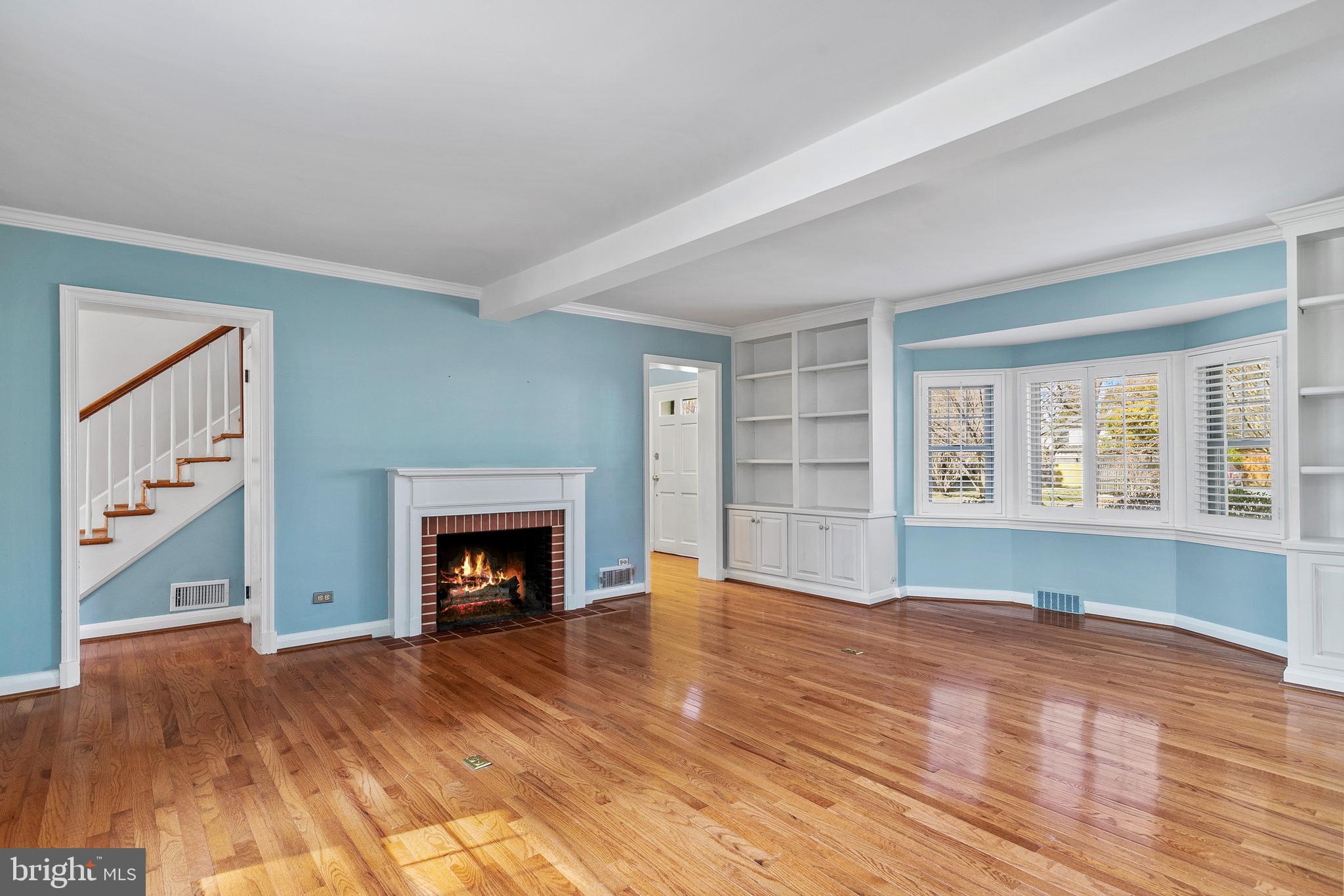 727 Whitehall Beach Road Annapolis, MD 21409 - Photo 17 of 44 an empty room with wooden floor fireplace and windows
