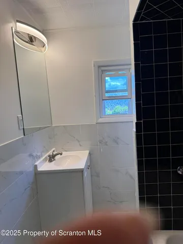 a bathroom with a bathtub a shower and a sink