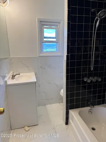 a bathroom with a black white checkered and a blue shower
