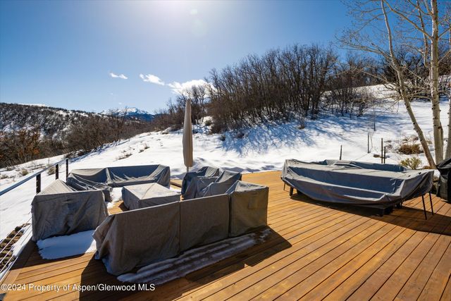 a view of a roof deck with couches and wooden floor