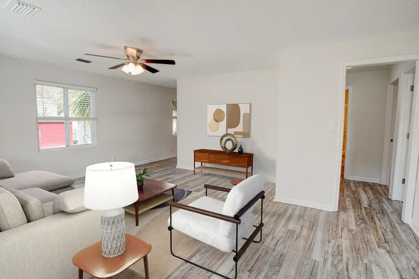 a living room with furniture and a wooden floor