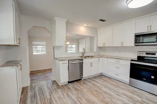 a kitchen with wooden floors and white appliances