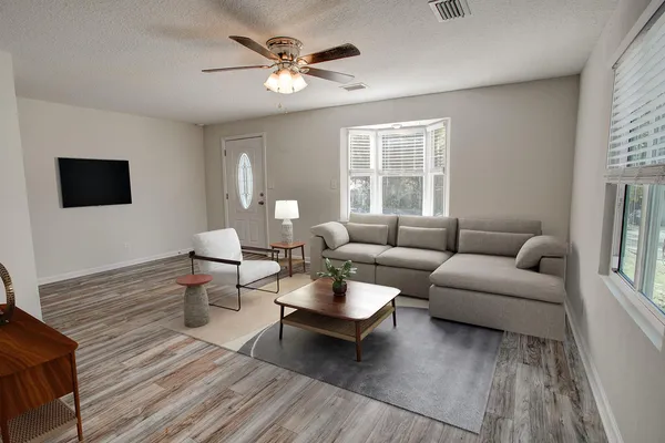 a living room with furniture a window and a flat screen tv