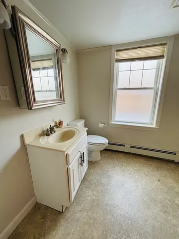 an empty room with a sink and mirror with window