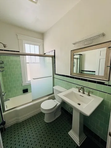 a bathroom with a sink toilet a mirror and shower