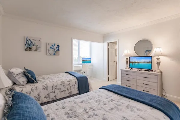 a bedroom with two bed and a flat screen tv