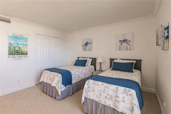 a bedroom with two beds and painting on the wall