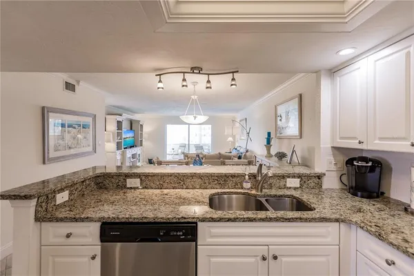 a kitchen with granite countertop a sink and cabinets