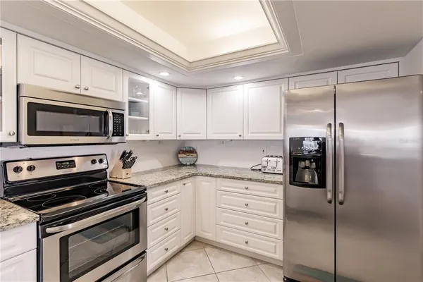 a kitchen with stainless steel appliances white cabinets and a stove top oven