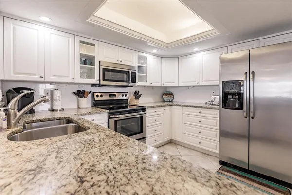 a kitchen with stainless steel appliances granite countertop a refrigerator sink and stove