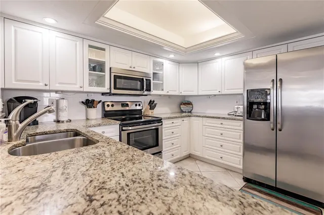 a kitchen with stainless steel appliances granite countertop a refrigerator sink and stove