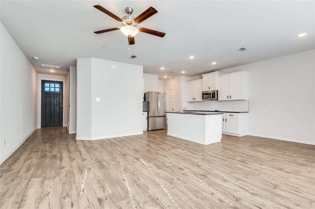 1118 Houston Way Lewisville, TX 75077 - Photo 2 of 12 a view of kitchen with kitchen island wooden floor center island and stainless steel appliances