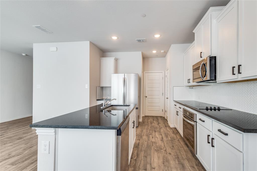 1118 Houston Way Lewisville, TX 75077 - Photo 5 of 12 a kitchen with stainless steel appliances a refrigerator a stove and white cabinets