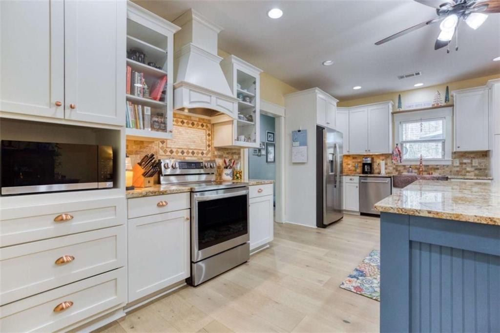 1948 Hearthstone Court Winder, GA 30680 - Photo 19 of 87 a kitchen with stainless steel appliances kitchen island granite countertop a refrigerator and a stove top oven