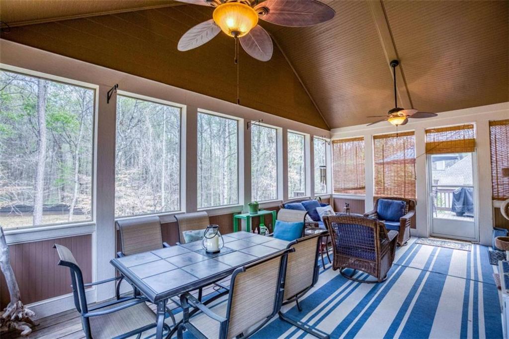 1948 Hearthstone Court Winder, GA 30680 - Photo 33 of 87 a dining room with wooden floor a chandelier a glass table and chairs