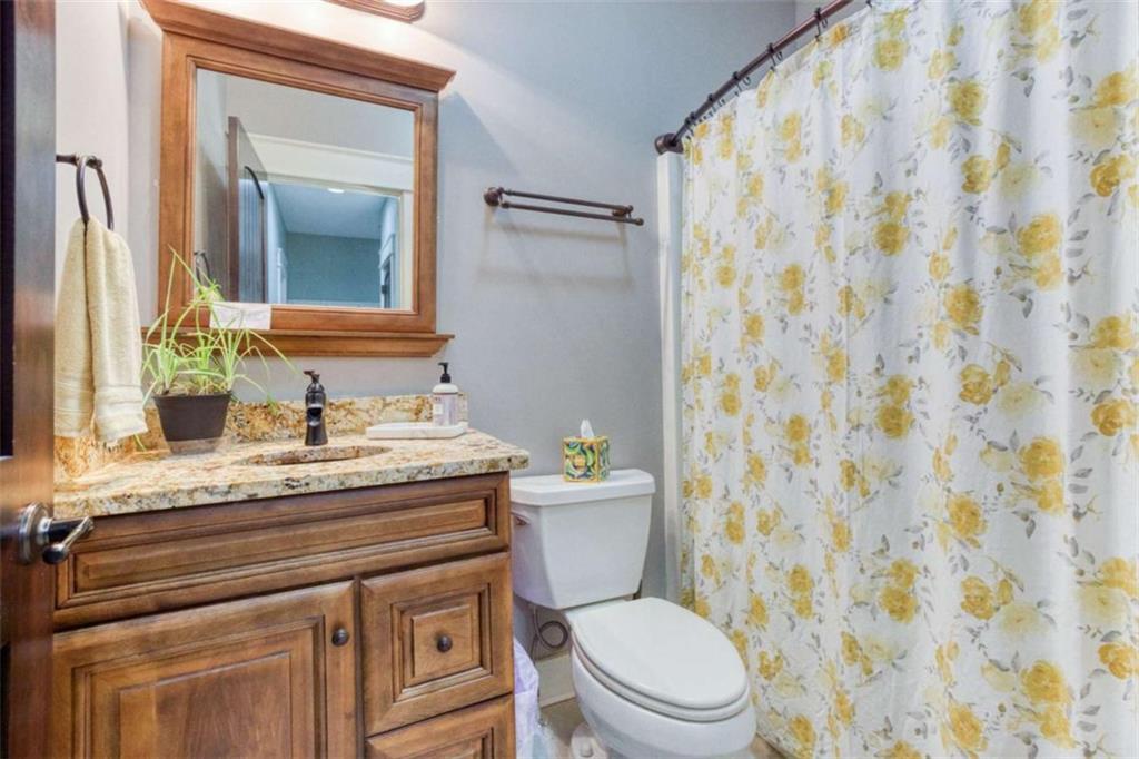 1948 Hearthstone Court Winder, GA 30680 - Photo 40 of 87 a bathroom with a granite countertop sink a toilet and a mirror