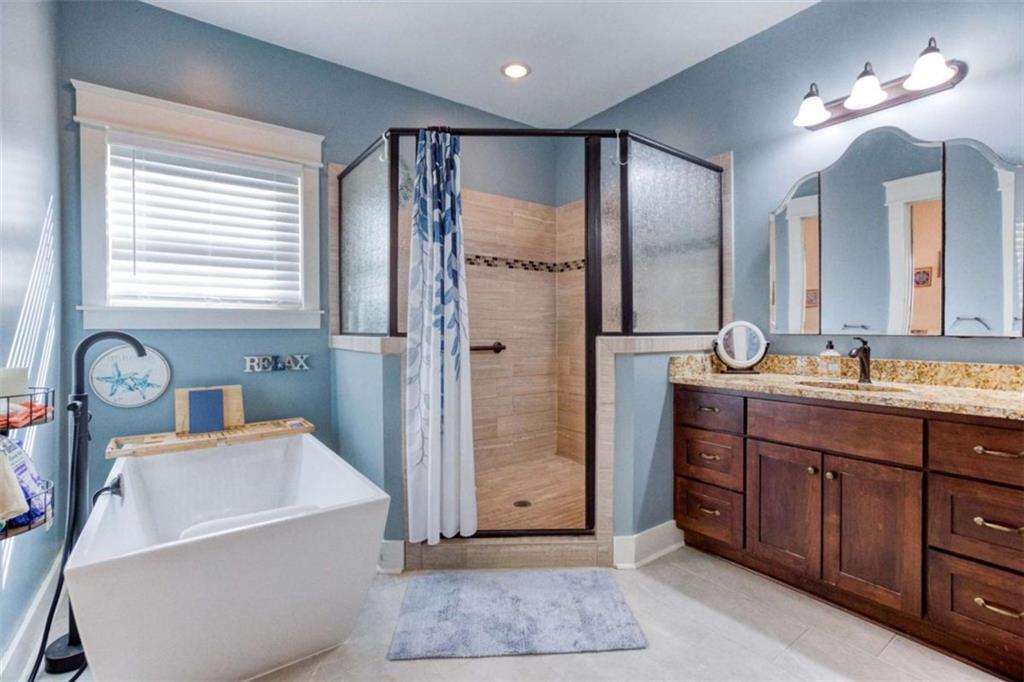 1948 Hearthstone Court Winder, GA 30680 - Photo 52 of 87 a bathroom with a granite countertop sink a mirror a vanity and a shower