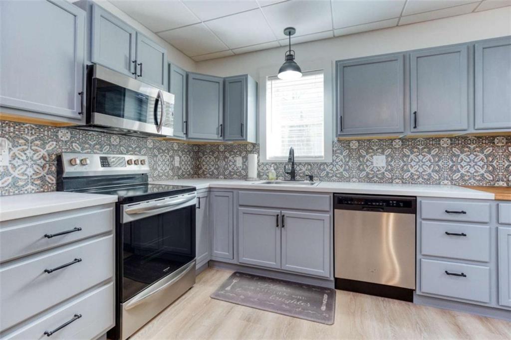 1948 Hearthstone Court Winder, GA 30680 - Photo 67 of 87 a kitchen with stainless steel appliances granite countertop a sink stove and microwave