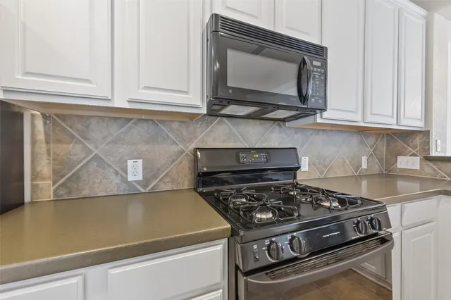 a kitchen with stainless steel appliances granite countertop a refrigerator stove microwave and sink