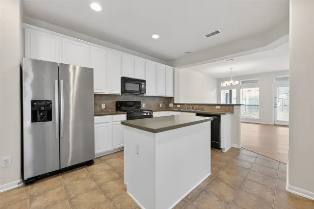 an empty room with windows and chandelier fan