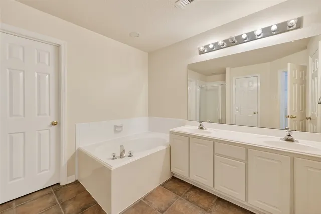 an empty room with a bathroom and a ceiling fan