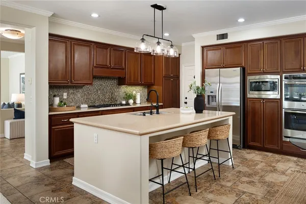 a kitchen with kitchen island granite countertop stainless steel appliances a sink and a refrigerator