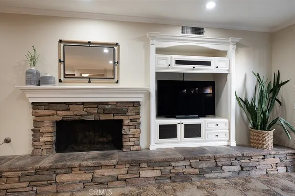 a living room with a fireplace and a potted plant