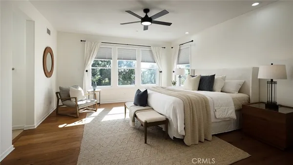 a spacious bedroom with a bed a couch and a chandelier