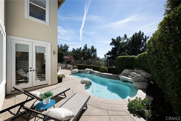 a view of a patio with couches table and chairs with plants and trees