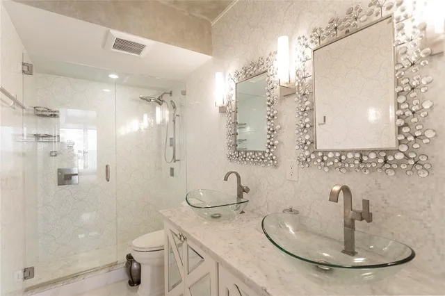 a bathroom with a sink a toilet and shower