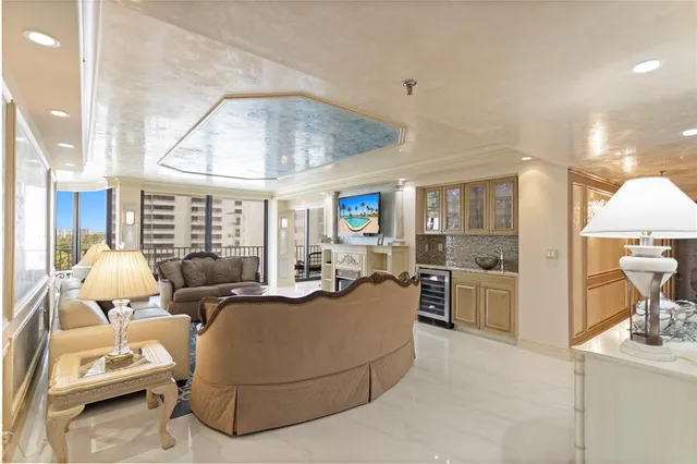 a living room with furniture a chandelier and a dining table