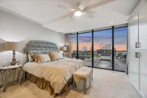 a bedroom with a large bed and a chandelier fan