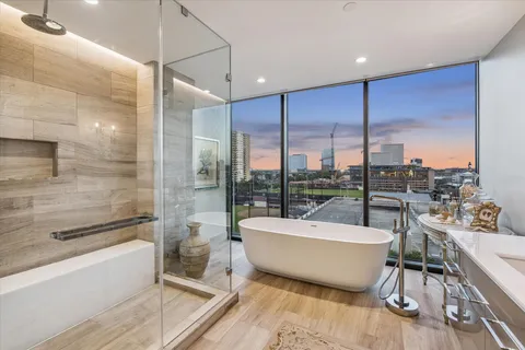 a bathroom with a large tub a mirror and a shower