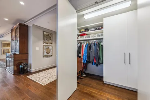 a view of walk in closet with clothes and shoes